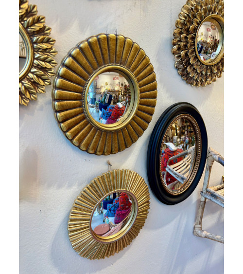 Miroir rond de style soleil avec cadre doré cannelé, au centre d'une composition murale décorative