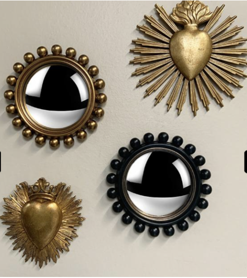 Miroir convexe doré vintage intégré dans une décoration murale élégante