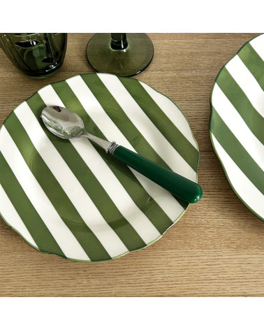 Assiette plate  de 19 cm à rayures vertes et blanches présentée sur une table avec une cuillère au manche vert.