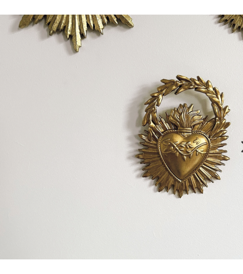 Ex-voto doré accroché au mur dans une décoration bohème chic