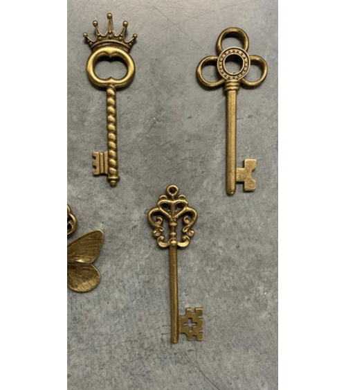 Assortiment de clés décoratives murales dorées comprenant les modèles trèfle, couronne et ailée pour décoration d'intérieur.