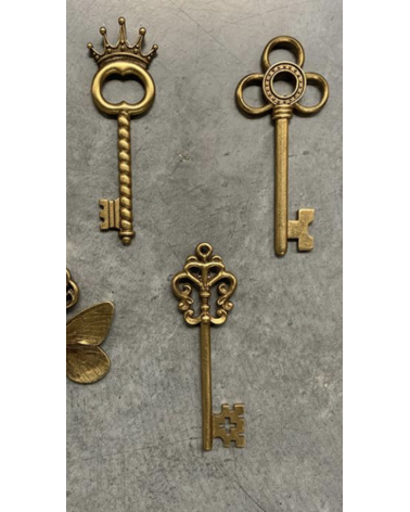 Assortiment de clés décoratives murales dorées comprenant les modèles trèfle, couronne et ailée pour décoration d'intérieur.