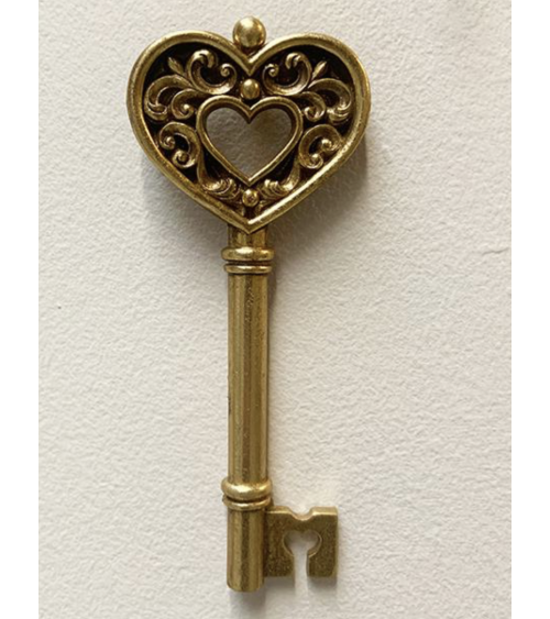 Décoration murale originale : clé ancienne dorée avec pommeau en forme de cœur travaillé et détails baroques.