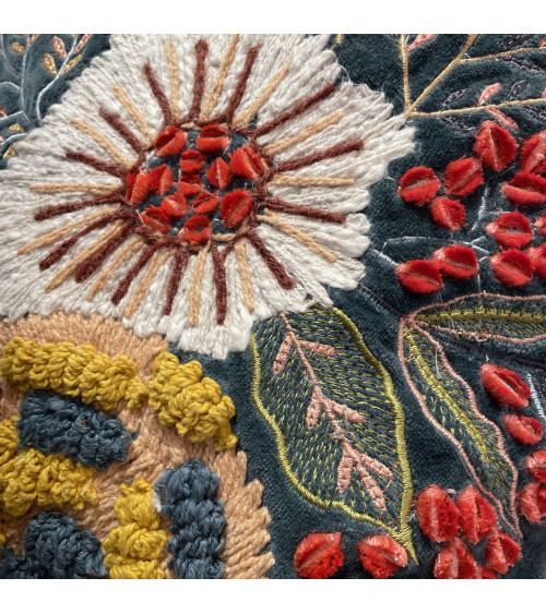 Zoom sur les détails des broderies en relief et points de chaînette sur velours haut de gamme.