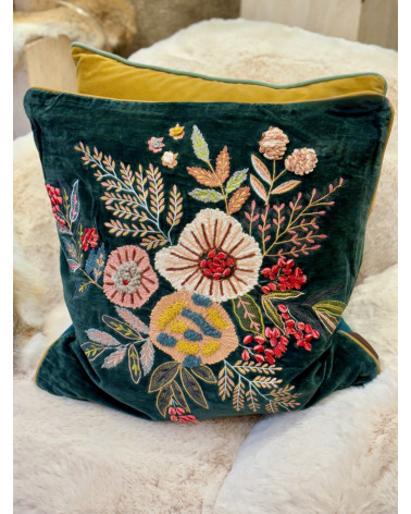 Coussin floral brodé exposé sur un fauteuil pour une décoration de salon bohème chic.