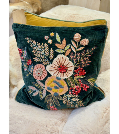 Housse de coussin en velours bleu ocean posée sur une fourrure blanche pour une décoration cocooning et élégante.