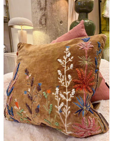 Gros plan sur les détails des broderies en relief aux motifs de fleurs sauvages et de plantes.