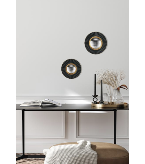 Deux miroirs fleurs convexes noir et doré installés au-dessus d'une console noire dans un intérieur moderne