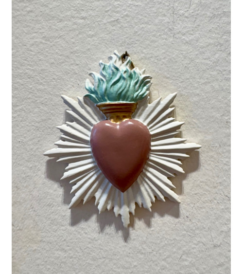 Décoration murale ex-voto en forme de cœur sacré coloris vieux rose avec flamme turquoise et rayons blancs.