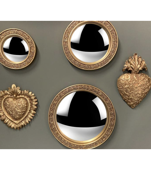 Ex-voto cœur doré exposé sur un mur avec des miroirs ronds pour une décoration murale style baroque