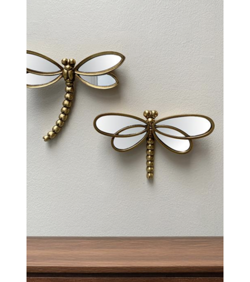 Décoration murale libellule dorée en miroir installée sur un mur