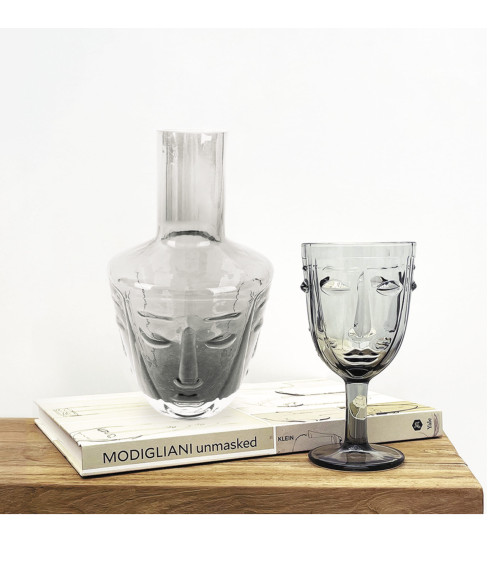 Carafe design en verre gris posée sur une table décorative