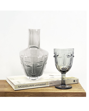 Carafe design en verre gris posée sur une table décorative