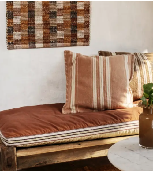 Coussin rose poudré et écru dans salon bohème naturel