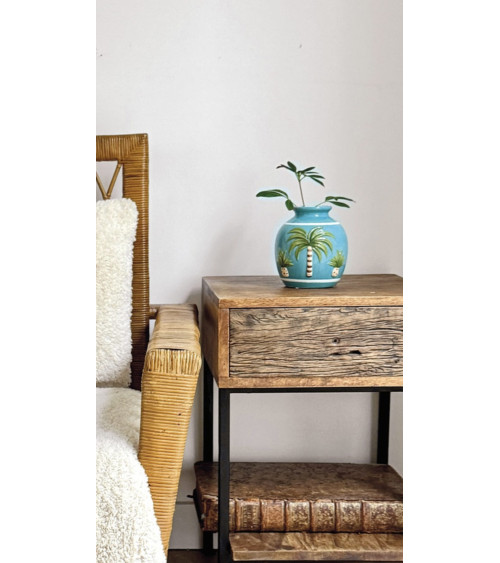 Vase décoratif tropical bleu sur meuble en bois et rotin