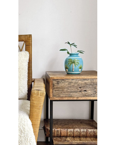 Vase décoratif tropical bleu sur meuble en bois et rotin