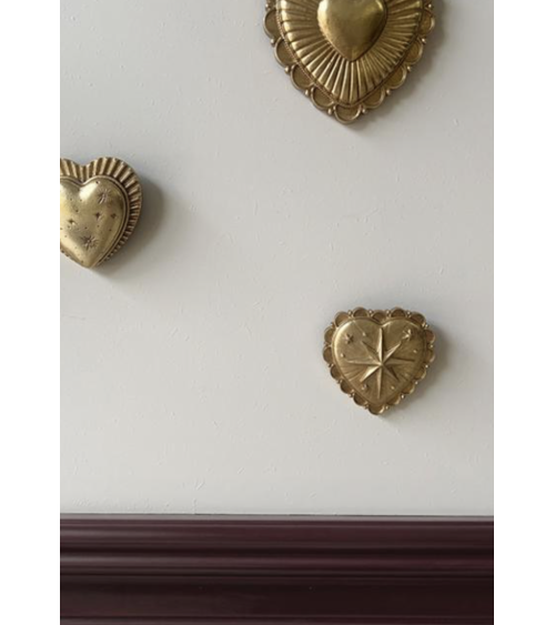 Composition murale d'ex-votos cœurs dorés dans une décoration intérieure