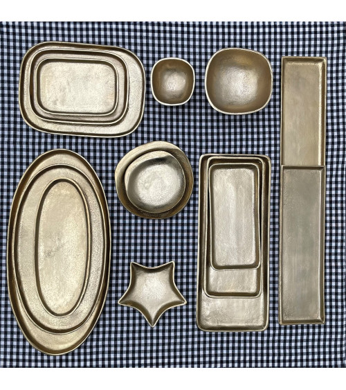 Grand plateau ovale en métal doré présenté avec la collection d'objets décoratifs assortis