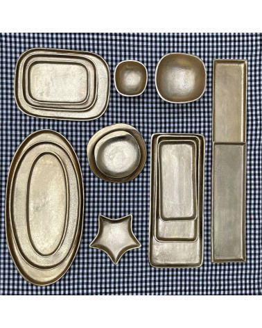 Grand plateau ovale en métal doré présenté avec la collection d'objets décoratifs assortis