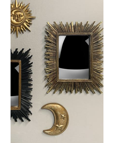 Miroir soleil doré dans une composition murale esprit cabinet de curiosités