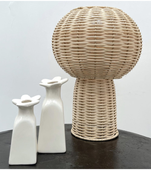 Vases fleur blancs en faïence dans une décoration avec lampe en rotin