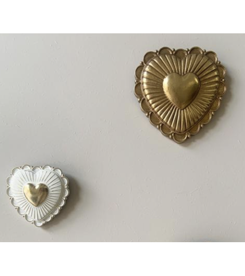 Ex-voto cœur blanc et doré dans une composition murale