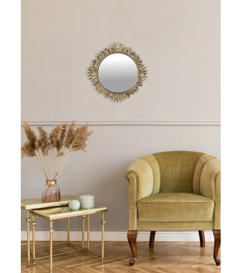 Miroir soleil feuilles dorées en décoration dans un salon