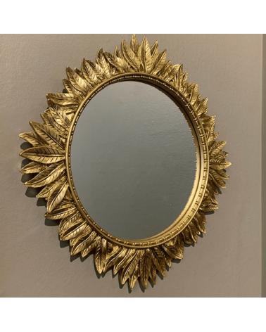 Miroir mural rond doré entouré de feuilles en relief