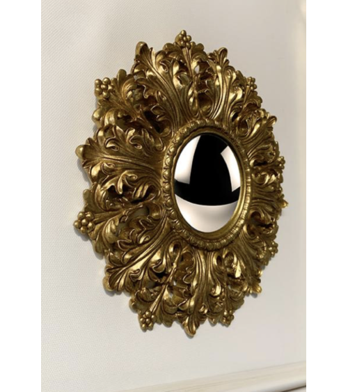 Miroir convexe doré ornemental installé au mur