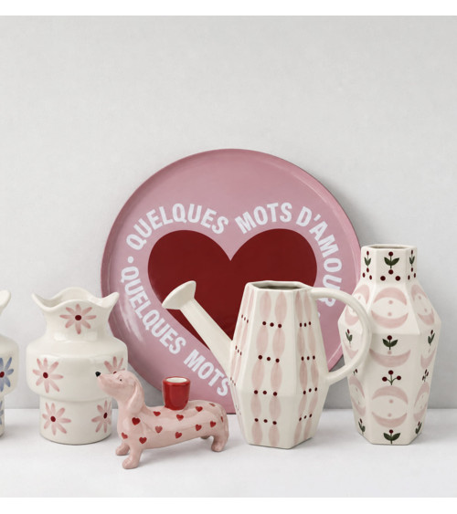 Arrosoir rose en céramique dans une décoration colorée