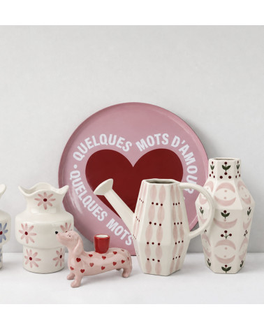 Arrosoir rose en céramique dans une décoration colorée